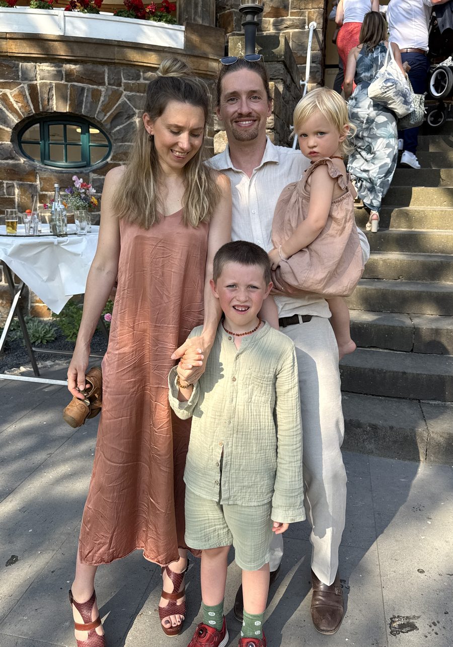 Christian, Lucy, Joris und Linnea festlich gekleidet auf einer Steintreppe bei der Hochzeit eines Freundes, drei Tage vor dem Abflug nach Australien